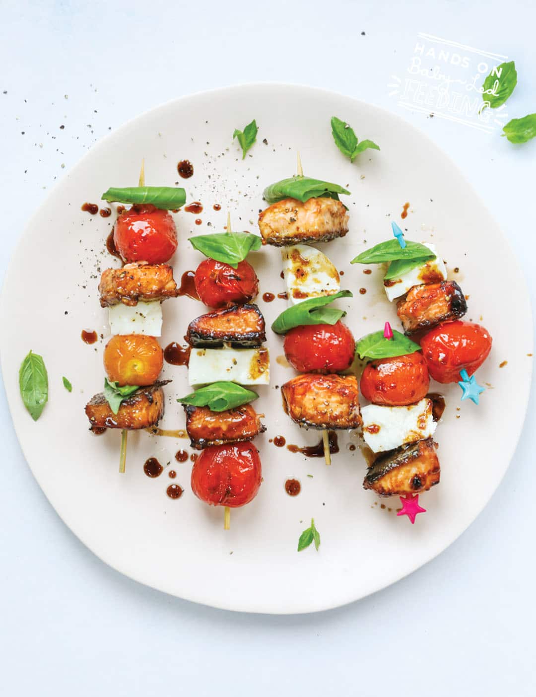 Baby Friendly Salmon Caprese Skewers are full of healthy Omega 3s and protein! This healthy summer dinner is perfect for the BBQ. Juicy grilled tomatoes and sticky sweet (refined sugar free) grilled salmon with fresh basil and mozzarella. Easy healthy baby led weaning. #babyledweaning #BBQ #babyledweaningdinner #babyledfeeding #omega3