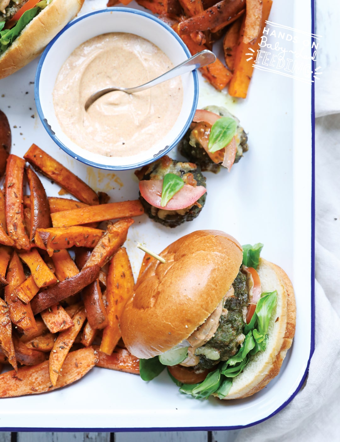 Veggie Loaded Baby Burgers with Cajun Sauce. This little burger is like an entire salad cooked into a slider sized burger! Served with a zesty (not spicy) yogurt based Cajun sauce and crispy-sweet sweet potato fries. #babyledweaning #sliders #bbq #healthyrecipe