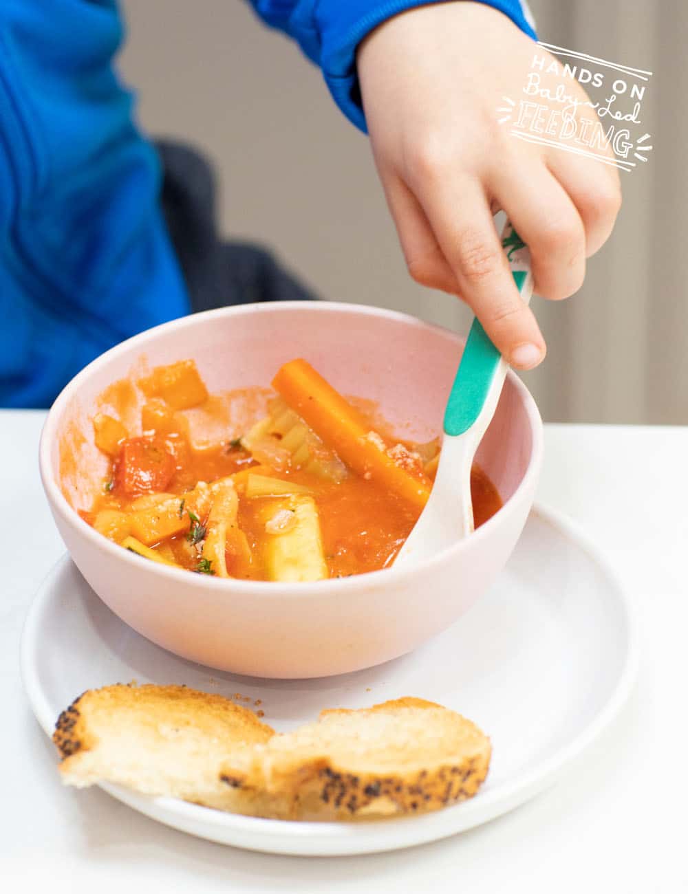 Warm Baby Led Weaning friendly veggie minestrone soup. Cutting veggies correctly for babies is the key to making this soup baby friendly! #soup #babyledweaning #vegan #vegetarian