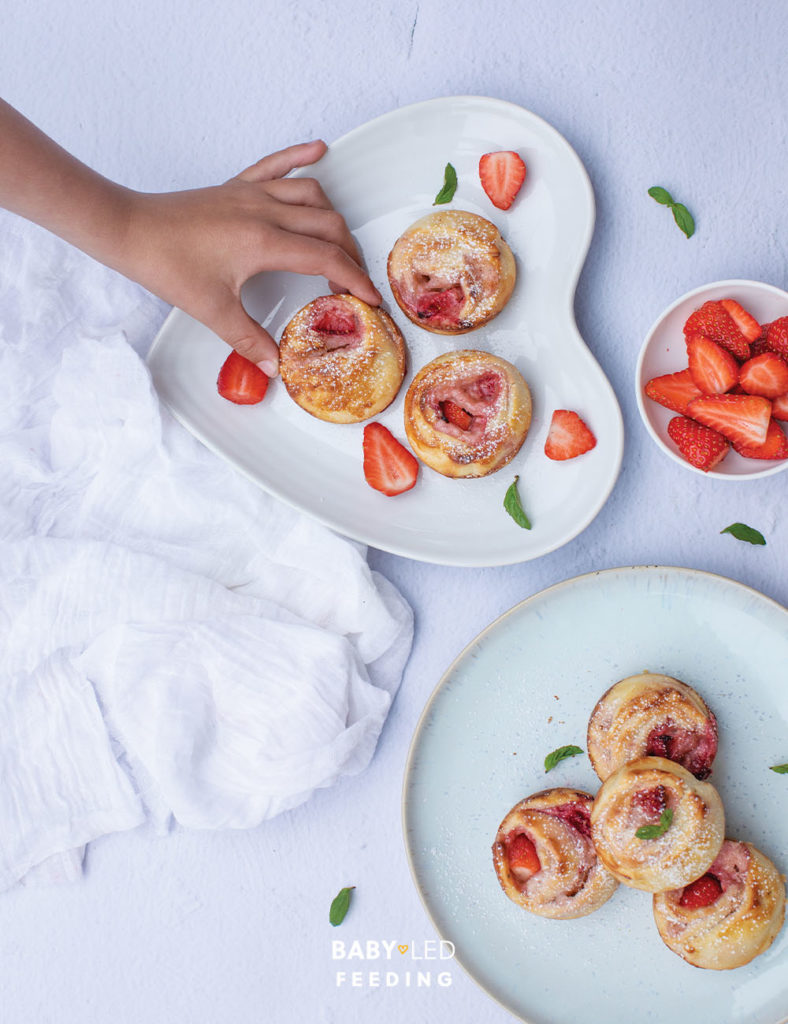 Strawberry and Cream Cheese Pinwheels with hand taking.
